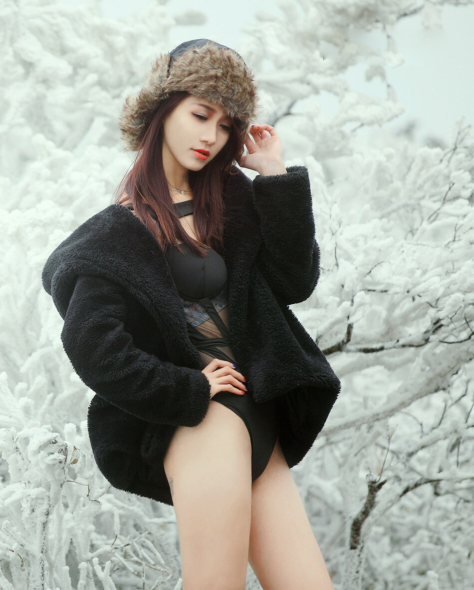 Beautiful girl shows her body in ice and snow